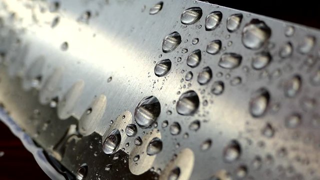 Chef's knife close-up. Knife santoku. blade blade. Drops of water flow down the blade of a knife. Cut vegetables. Cook lunch. Reflection of cold weapons.