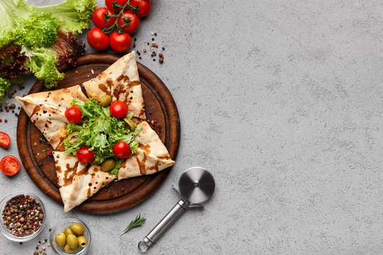Pizza in star shape decorated with lettuce and cherry tomatoes