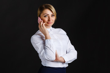 Beautiful young woman using smart phone with black background