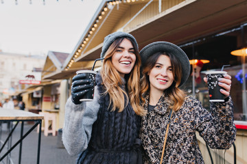 Selfie portrait of joyful fashionable girls having fun on sunny street in city. Stylish look, having fun, travelling with friends, smiling, expressing true positive emotions