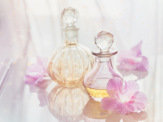 Spa still life with perfume and aromatic oils bottles surrounded by flowers