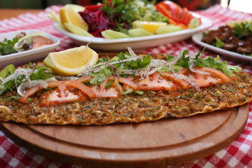 very thin turkish pizza covered with seasoned minced meat and onions 
