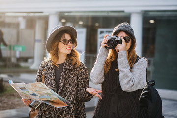 Stylish city portrait of two fashionable girls walking in Europe modern city centre. Fashionable...