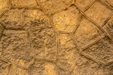 Polygonal rough brown and ochre cement wall texture background