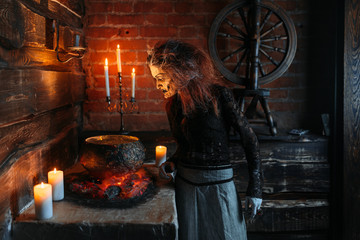 Scary witch reads spell over the pot, seance