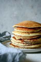 Sweet Homemade Stack of Pancakes with  honey for Breakfast  on a gray background. Sweet beautiful breakfast. Brunch. Family Breakfast. Concept for cafes, restaurants, fast food outlets, bars