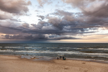 Fototapeta na wymiar People on the beach, sunset over polish sea baltic