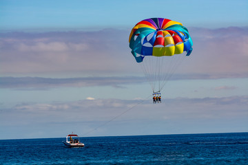 Sea and beach sport for tourists, parasailing in blue sky