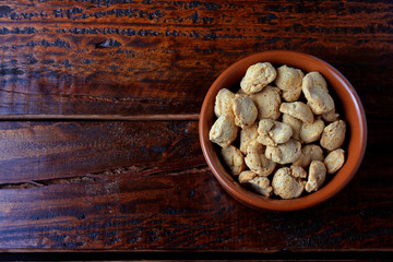 Soybeans meat, chunks in a brown ceramic bowl. Raw soybeans chunks on rustic wooden background