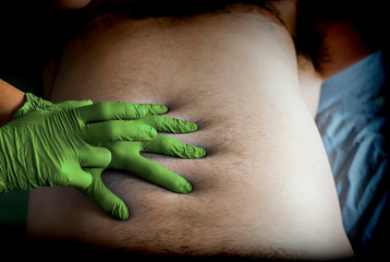 Doctor preparing abdominal palpation in a hospital, conceptual image, horizontal composition - obrazy, fototapety, plakaty