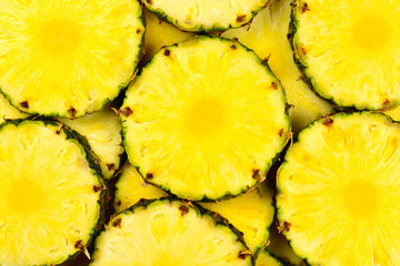 Pineapple juicy yellow slices background. Top view.