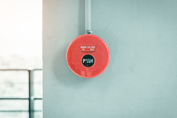 Red fire alarm button on wall.