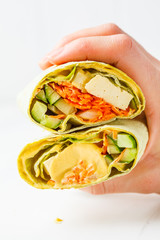 Vegan tofu wraps with cashew cheese sauce and vegetables, white background.