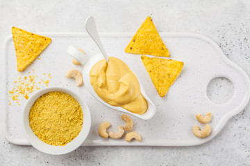 Vegan Cashew Cheese Sauce in white sauceboat, white background, top view.