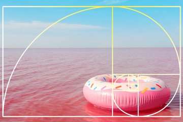 Bright inflatable ring floating in pink lake on summer day