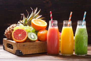 bottles of fruit juice and smoothie with fresh fruits - obrazy, fototapety, plakaty
