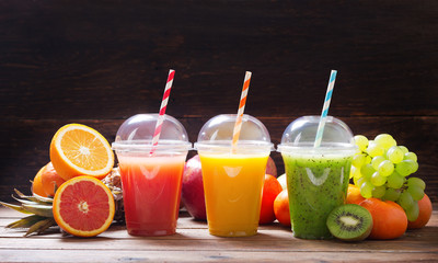 glasses of fruit juice and smoothie with fresh fruits