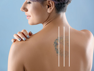 Beautiful tattoo on female back against color background