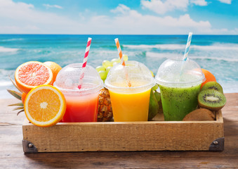 glasses of fruit juice and smoothie with fresh fruits