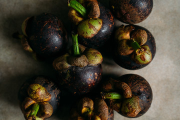 Fresh mangostine. Fresh Tropical Fruits. On a grey background. Top view.