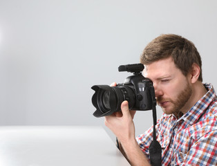 Obraz premium Man with professional camera in photo studio. Space for text