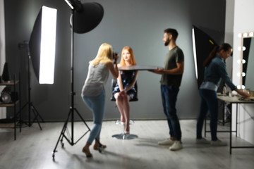 Obraz premium Blurred photo studio with professional equipment and team of workers
