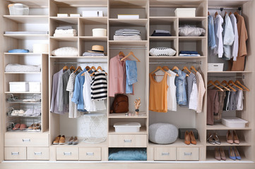 Stylish clothes, shoes and home stuff in large wardrobe closet