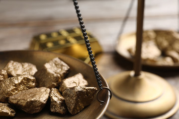 Scale pan with gold lumps on table, closeup. Space for text