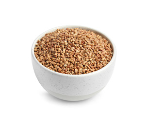 Bowl with uncooked buckwheat on white background
