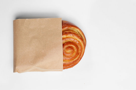 Paper bag with bun on white background, top view. Space for design