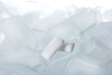 Chewing gums on ice cubes against white background, closeup