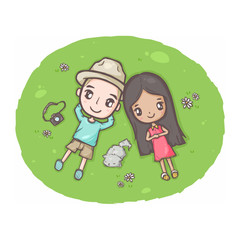 Cute couple moment a guy and a girl lying down in the garden with a cat