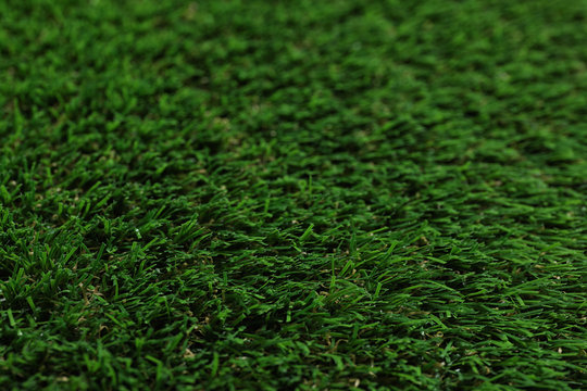 Green artificial grass texture as background, closeup