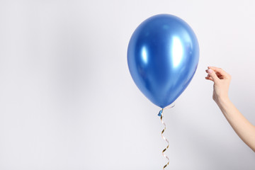 Woman piercing balloon with needle on white background, closeup © New Africa