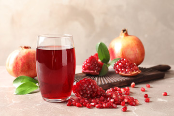 Composition with glass of fresh pomegranate juice on table