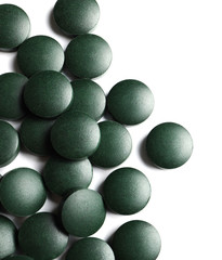 Spirulina tablets on white background, top view