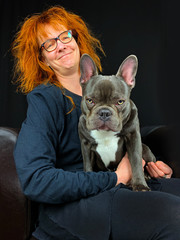 a grinning woman and her grim looking French Bulldog