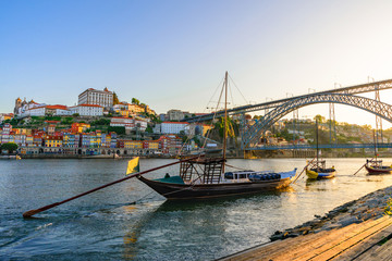 Porto, Portugal old town cityscape on the Douro River with traditional Rabelo boats with wine barrels and bridge - obrazy, fototapety, plakaty