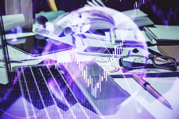 Double exposure of stock market chart and office desktop on background. financial strategy concept.