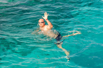 man with snorkel mask tuba and snorkel in sea. Snorkeling, swimming, vacation. Tourists are engaged in snorkeling in the open sea. Holidays in the seaside resort