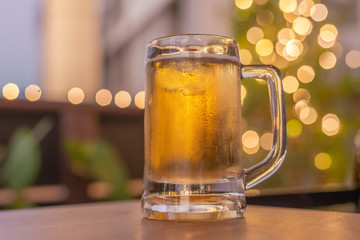 cold beer glass on a bar scene in the background
