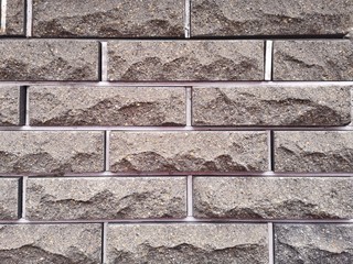 Gray wall of textured bricks. Empty grey brick wall background with concrete and rough aged structure. Neat brickwork for building. Grunge bricks wallpaper 