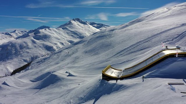 Aerial view of Alps in winter, ski jumping slopes, hills covered with snow - Alps from above, Livigno, Italy, Europe