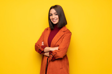 Young woman with coat with arms crossed and looking forward