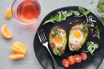 Keto diet dish: Avocado boats with ham cubes, quail eggs and cheese, top lay