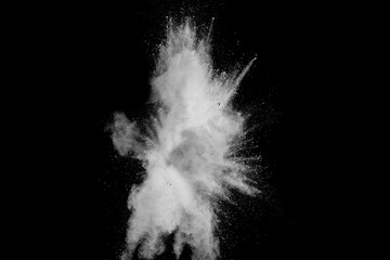 White powder explosion isolated on black background. White dust particles splash.Color Holi...