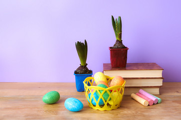 School supplies, Easter eggs and flowers on wooden table