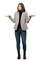 A full-length shot of a Young business woman having doubts while raising hands over isolated white background © luismolinero