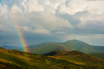 Summer in the Carpathian massif of Swidovets, located in Ukraine, with a lot of lakes, green pasture for sheep and horses, and wonderful, after a stormy sky with a rainbow.