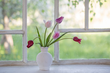 tulips in vase on old windowsill